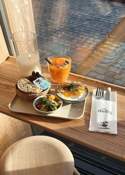 Brunchbakke med juice og brød ved vinduet